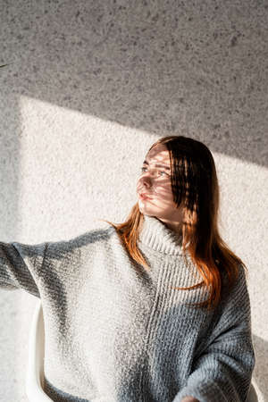 Light and shadow portrait. Beautiful young woman with a shadow pattern on the face in the form of...
