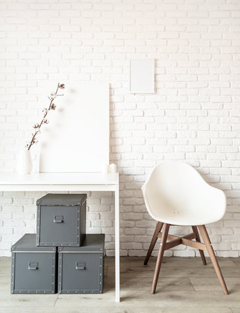 mock up poster frame with cotton branch on the table on white brick wall background. Copy spaceの写真素材