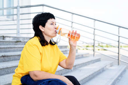 Sport and fitness. Senior sport. Active seniors. Smiling senior sportswoman doing selfie outdoors in the parkの写真素材