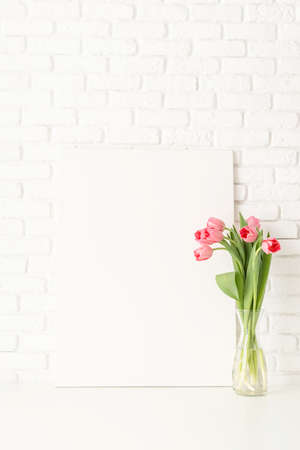 White card or menu card with spring tulips top view over white wooden background. Mock up design.の写真素材