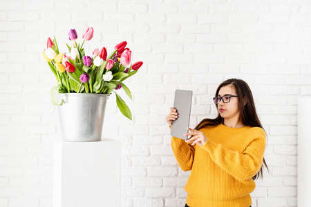 Small business concept. Spring holidays. Mock up of desk calendar with colorful tulips