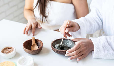 Spa and wellness concept. Self care. two beautiful women applying facial cream doing spa proceduresの写真素材
