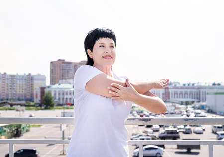 Sport and fitness. Senior sport. Active seniors. Smiling senior woman doing stretching outdoors on...