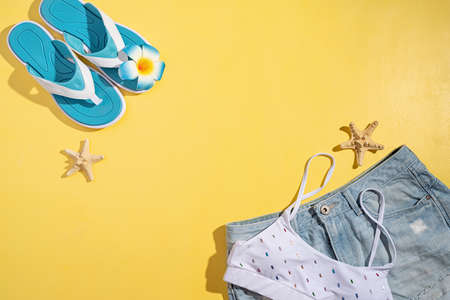 Summer and vacation concept. summer accessories with clothes, shoes, tropical leaves and flowers, flat layの写真素材