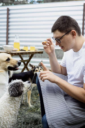 Caucasian man kissing a dog, walking outdoors in the backyardの写真素材