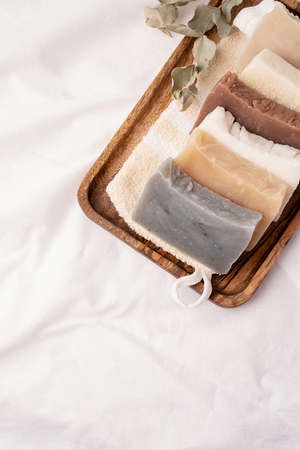 Natural organic cosmetics. Stack of hand made soap in wooden tray on white backgroundの写真素材