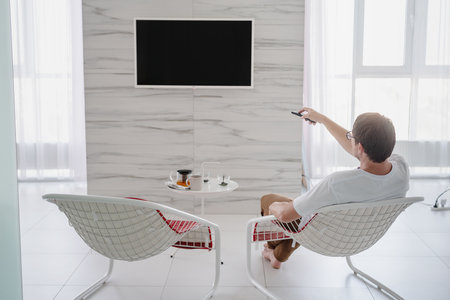Social distancing. E-learning and teaching. Young man in white shirt and black protective maskusing...