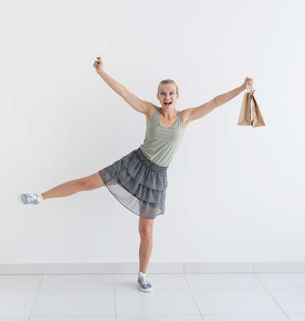 Healthcare and quarantine concept. Young woman dancing ballet with shopping bags in a protective...