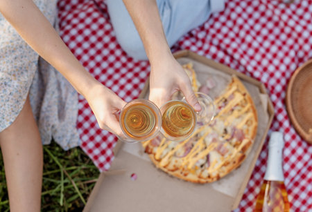 Autumn nature. Fun and liesure. Young teenage couple picnic on sunflower field in sunset drinking champagneの写真素材