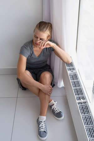 Mental health. Depressed woman touching her face with hands, having headacheの写真素材