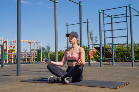Healthy and active lifestyle. Sports and fitness. Young sportive woman in sport clothes drinking water from bottle on sport groundの写真素材