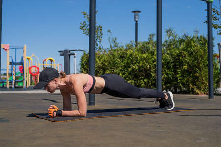 Healthy and active lifestyle. Sports and fitness. Young sportive woman in sport clothes drinking water from bottle on sport groundの写真素材