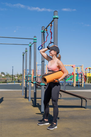 Healthy and active lifestyle. Sports and fitness. Young sportive woman in sport clothes drinking...
