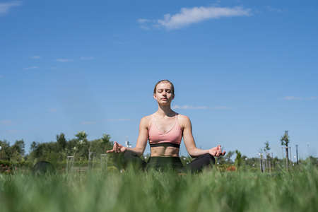 Healthy and active lifestyle. Sports and fitness. Young sportive woman in sport clothes drinking water from bottle on sport groundの写真素材