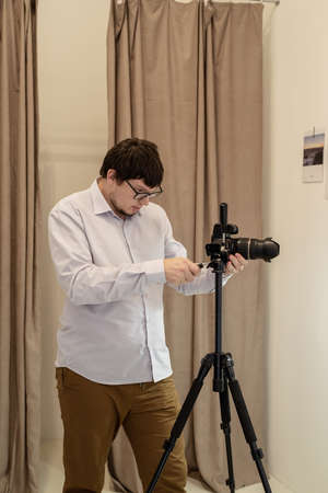 Minimal light and airy interior design. Male photographer working in minimal light and airy interior, white and beige chair, rug and pillowsの写真素材
