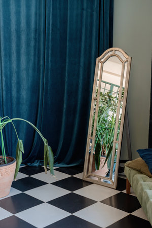 Stylish living room design. Living room corner interior with mirror, blue curtain and plantsの写真素材