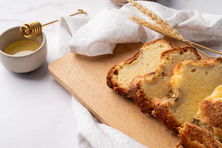 Baking and cooking. High angle view of sliced banana bread on light concrete background with honey....