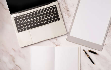 Top view desk arrangement. Top view desktop blank calendar for mockup, notebook and laptop on light...