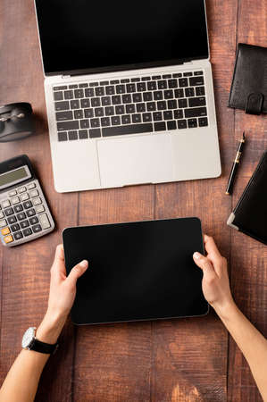 Top view desk arrangement. Top view desktop blank tablet, laptop and stationery on wooden background, copy space for textの写真素材