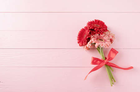 happy birthday. Red gerbera daisy flowers on pink wooden table, flat layの写真素材