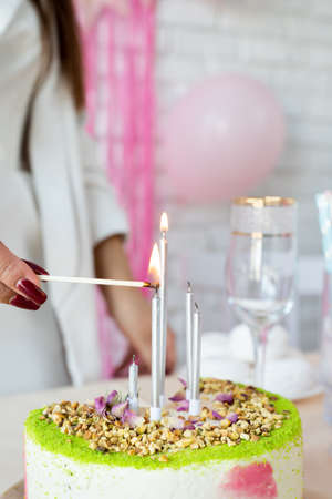 birthday party. birthday tables. Attractive woman in white party clothes preparing birthday table...