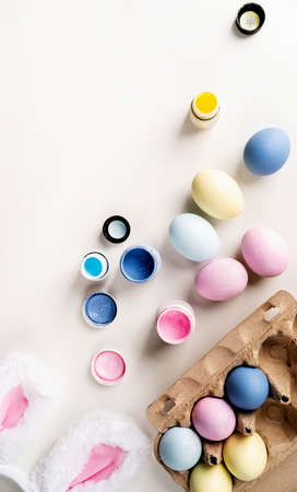 Woman preparing for Easter. Home decoration for holiday. coloring easter eggs with pastel paints,...
