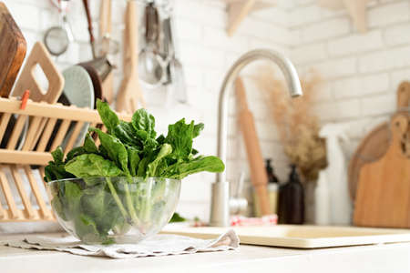 Preparing healthy foods. Healthy eating and dieting. fresh spinash in a bowl in the kitchen. closeup...