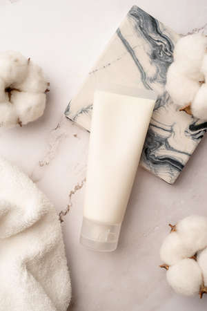 Mockup facial skincare product white tube with blank label on marble background, Top viewの写真素材