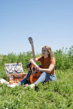 Young woman in park outside at sunny day, enjoying summertime dreaming and drinking wine. Millennial...