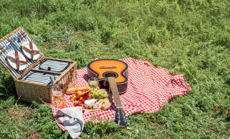Closeup of picnic basket with drinks and food on the grass. Nice picnic on sunny summer day, fun and leisureの写真素材
