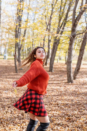 autumn nature. Young caucasian woman wearing sweater, enjoying nature in autumn forestの写真素材