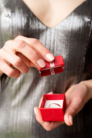 woman hand holding wedding ring in red box, wedding and holidaysの写真素材