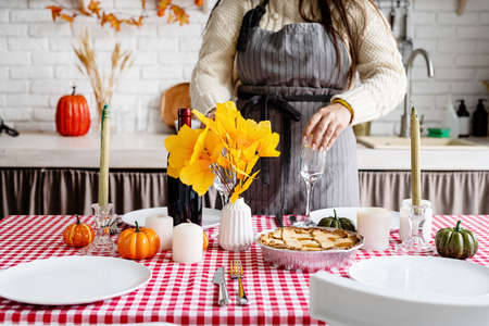 Happy Thanksgiving Day. autumn feast. Woman celebrating holiday cooking traditional dinner at kitchen, decorating homeの写真素材
