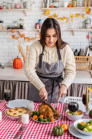 Woman celebrating holiday cooking traditional dinner at kitchen with turkeyの写真素材