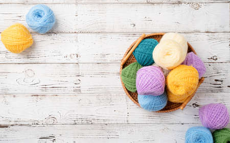 bright colorful yarn wool in a basket on wooden background
