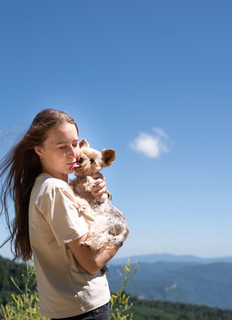 pet care. Travelling. Young pretty caucasian woman smiling holding small dog yorkshire terrier. Woman travel with pet looking at viewの写真素材