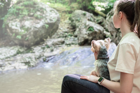 pet care. Travelling. Young pretty caucasian woman smiling holding small dog yorkshire terrier. Woman travel with pet looking at viewの写真素材