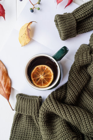 hello fall. Cozy warm image. Cozy autumn composition, sweater weather. Pumpkins, hot tea with lemon and sweaters on windowの写真素材