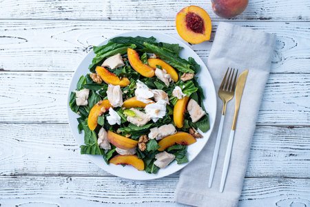 top view plate with tasty peach and spinach salad on wooden table with copy spaceの写真素材
