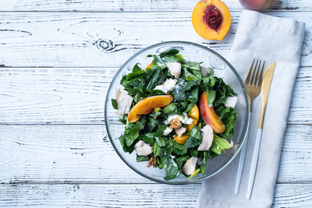 top view plate with tasty peach and spinach salad on wooden table with copy spaceの写真素材