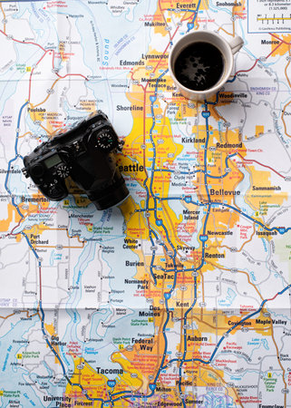 Flat lay traveler accessories on map, camera and cup of coffee. Top view travel or vacation conceptの写真素材