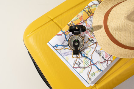 traveler accessories on yellow bag, map, hat, compass. Top view travel or vacation conceptの写真素材