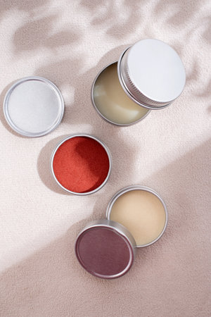 colorful lip balms in round tin cases on leather with shadow overlay, mockup design, labelの写真素材