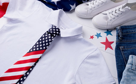 USA Memorial day, Presidents day, Veterans day, Labor day, or 4th of July celebration. Mockup design white polo t shirt for logo, top view on white wooden background with US flag, shoes and jeansの写真素材