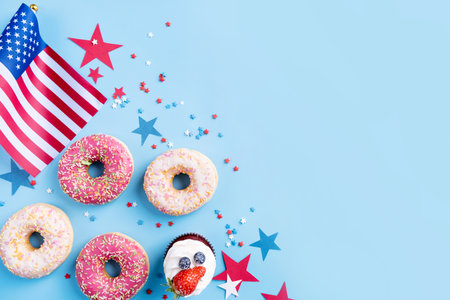 Fourth of july celebration. Sweet cupcakes and donuts with usa flag on blue backgroundの写真素材