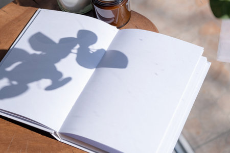 Magazine and book mockup design. Blank magazine on modern wooden table with candles, shadow overlay....