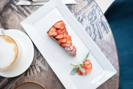 Piece of delicious cheesecake with berries on real cafe table close up, top viewの写真素材