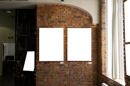 Blank picture frames on brick wall with glowing lamp in the gallery , mock up