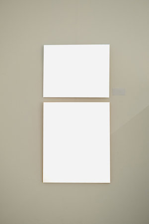 Blank picture frames on gray wall with glowing lamp in the gallery , mock upの写真素材