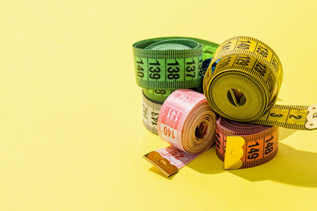 Dieting concept. colorful measuring tapes top view on bright yellow background